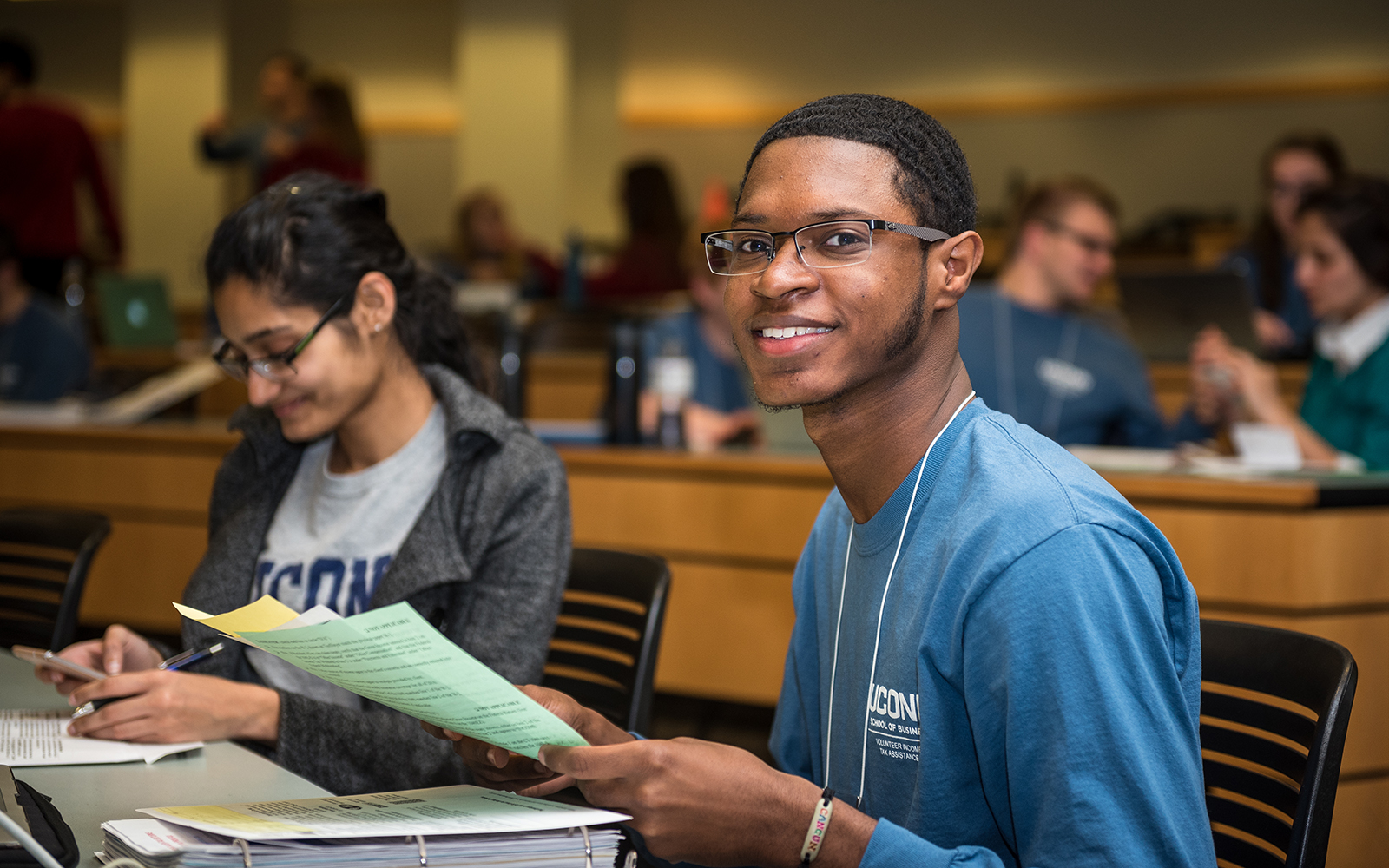Sameir Rankins '17, right, helps a client with her tax return (Devin Basdekian/UConn School of Business)