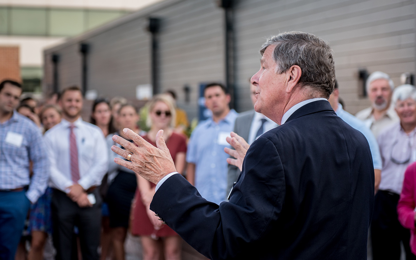 John Elliott, dean, greets School of Business alumni gathered at a rooftop reception celebrating the opening of the first residence hall to serve the Stamford campus. (Nathan Oldham/UConn School of Business)