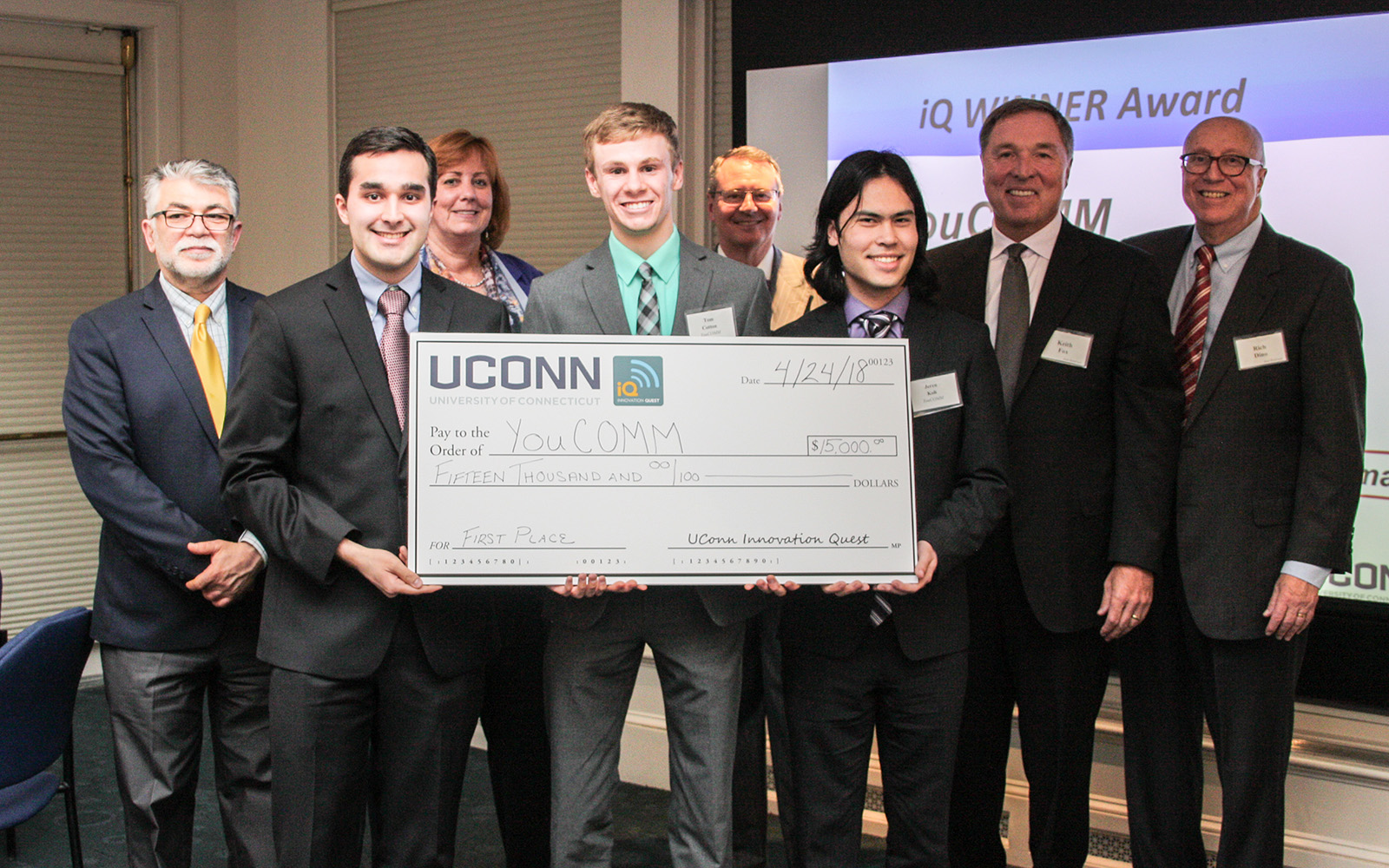 From left, Kazem Kazerounian, dean of the School of Engineering; YouCOMM co-founder Daniel Yasoshima; Lucy Gilson, head of the Management Department; YouCOMM co-founder Tom Cotton; Provost Craig Kennedy; student Jeren Koh; UConn iQ founder Keith Fox '80 and iQ Director Professor Rich Dino pose for a photo after the announcement that YouCOMM won the grand prize. (Nicolle Anderson/UConn School of Business)