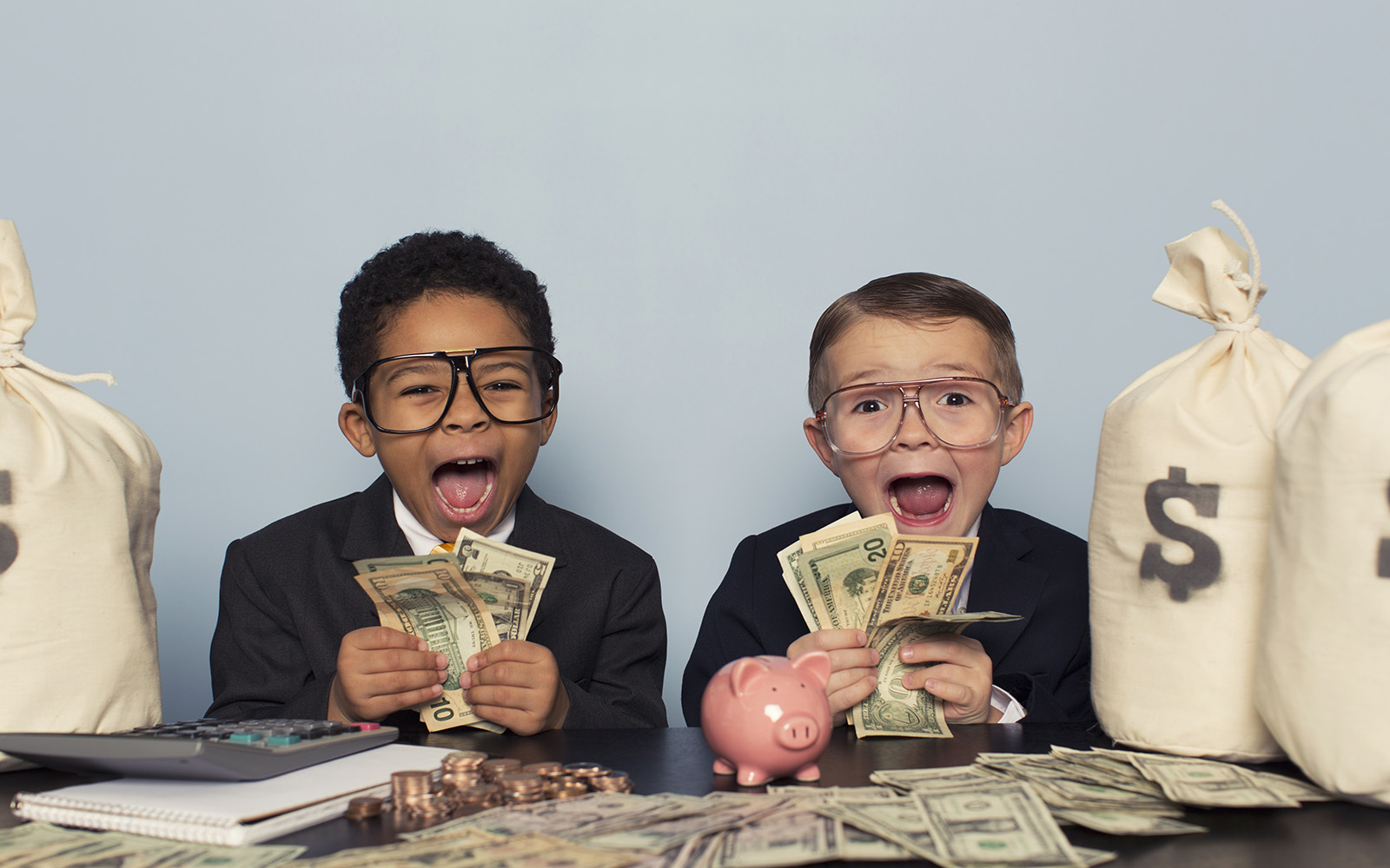 Young Business Children Make Faces Holding Lots of Money