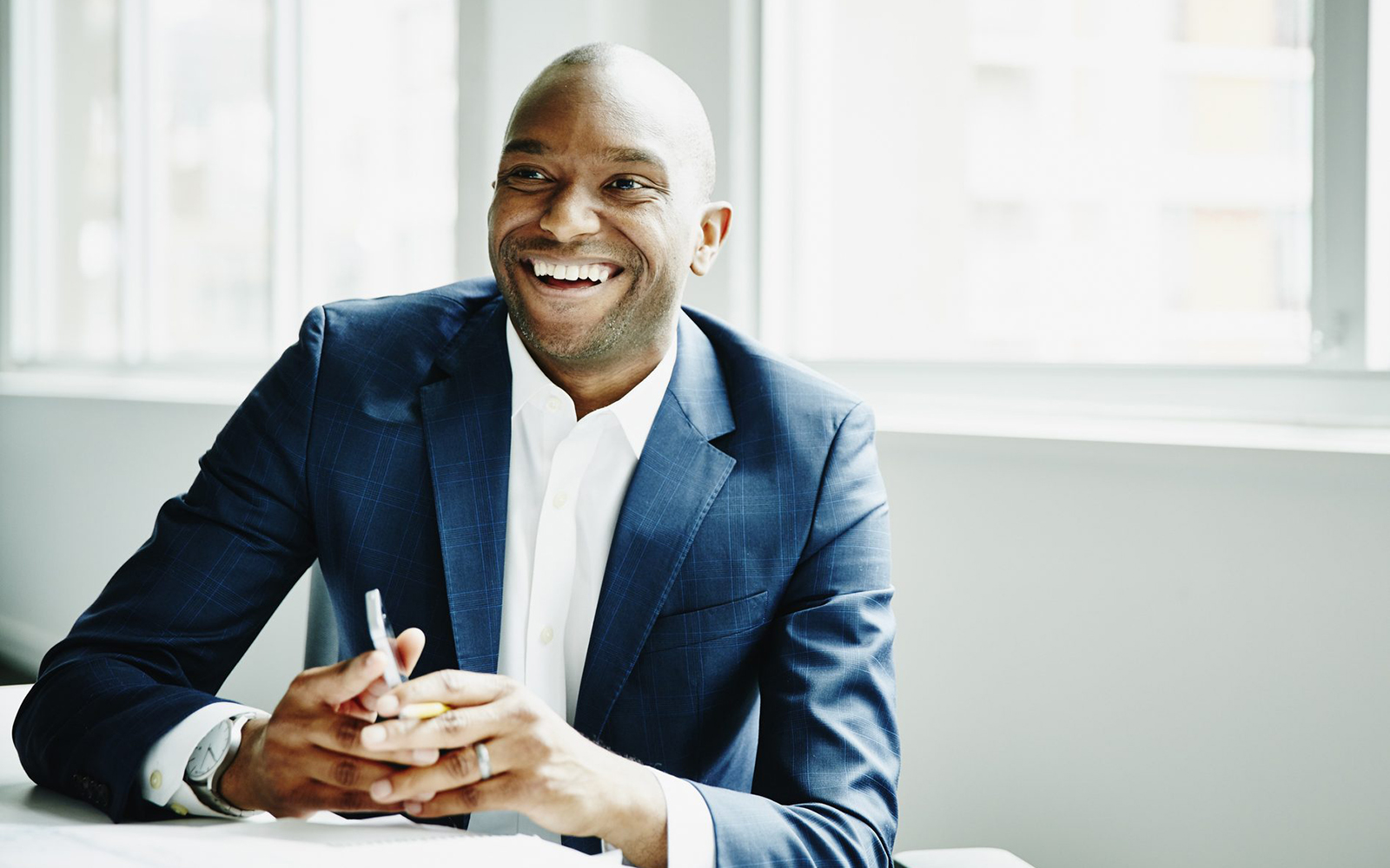 Stock photo of a man of color in a business suit, smiling.