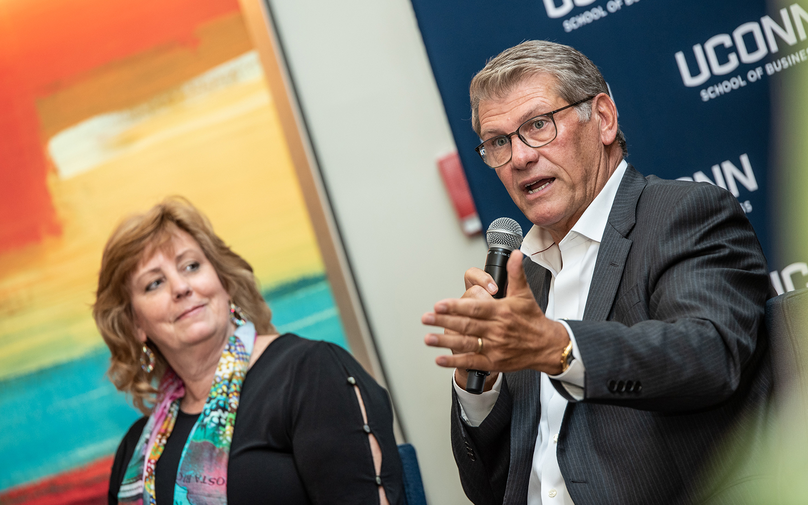 Lucy Gilson (left), Associate Dean of the UConn School of Business and Geno Auriemma (right), Head Coach of UConn Women's Basketball, speak during the first day of the Leadership Conference.  This year's program focused on leading through complexity and uncertainty. (Nathan Oldham / UConn School of Business)