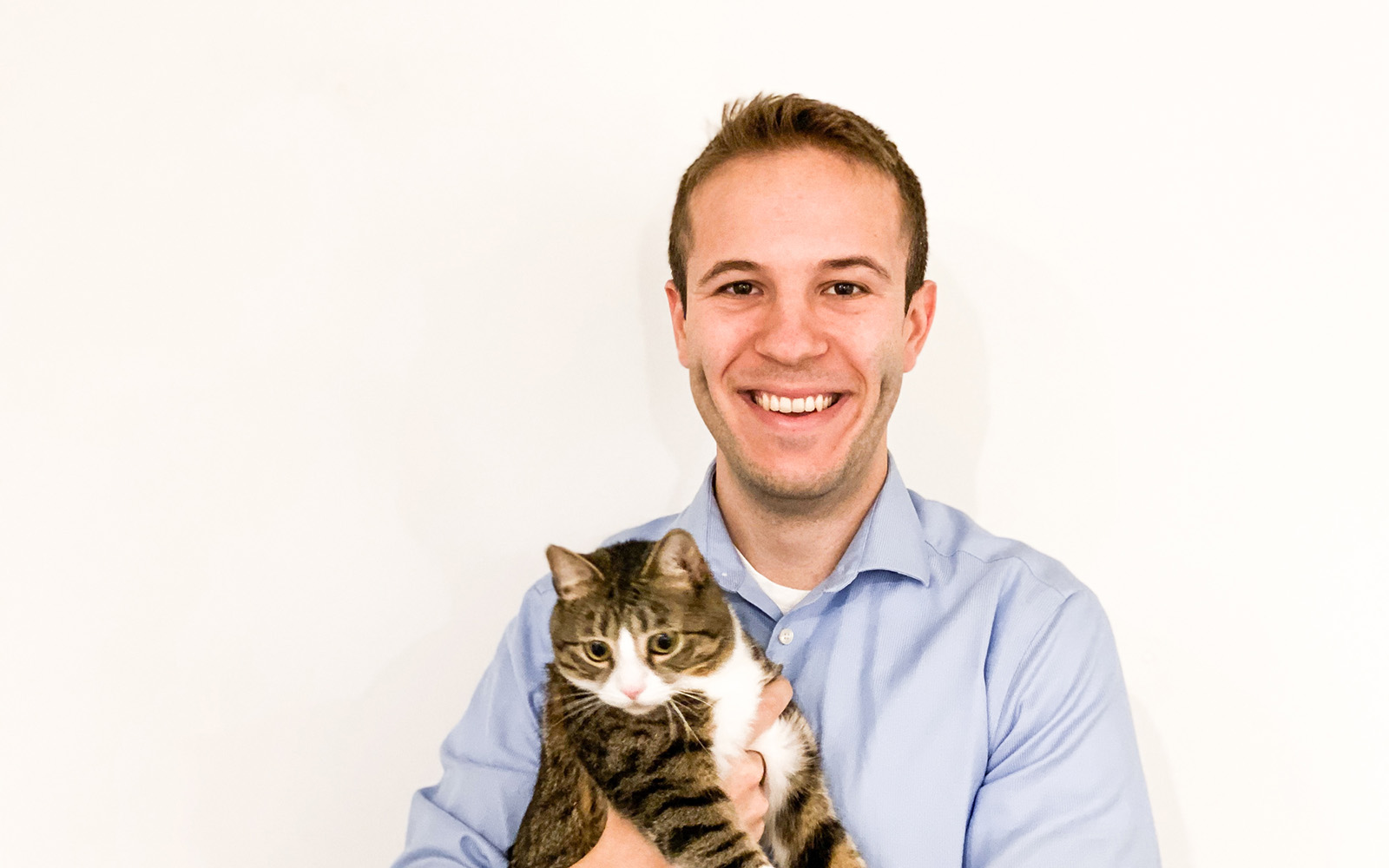 Travis Bloom poses with his cat, Ginny
