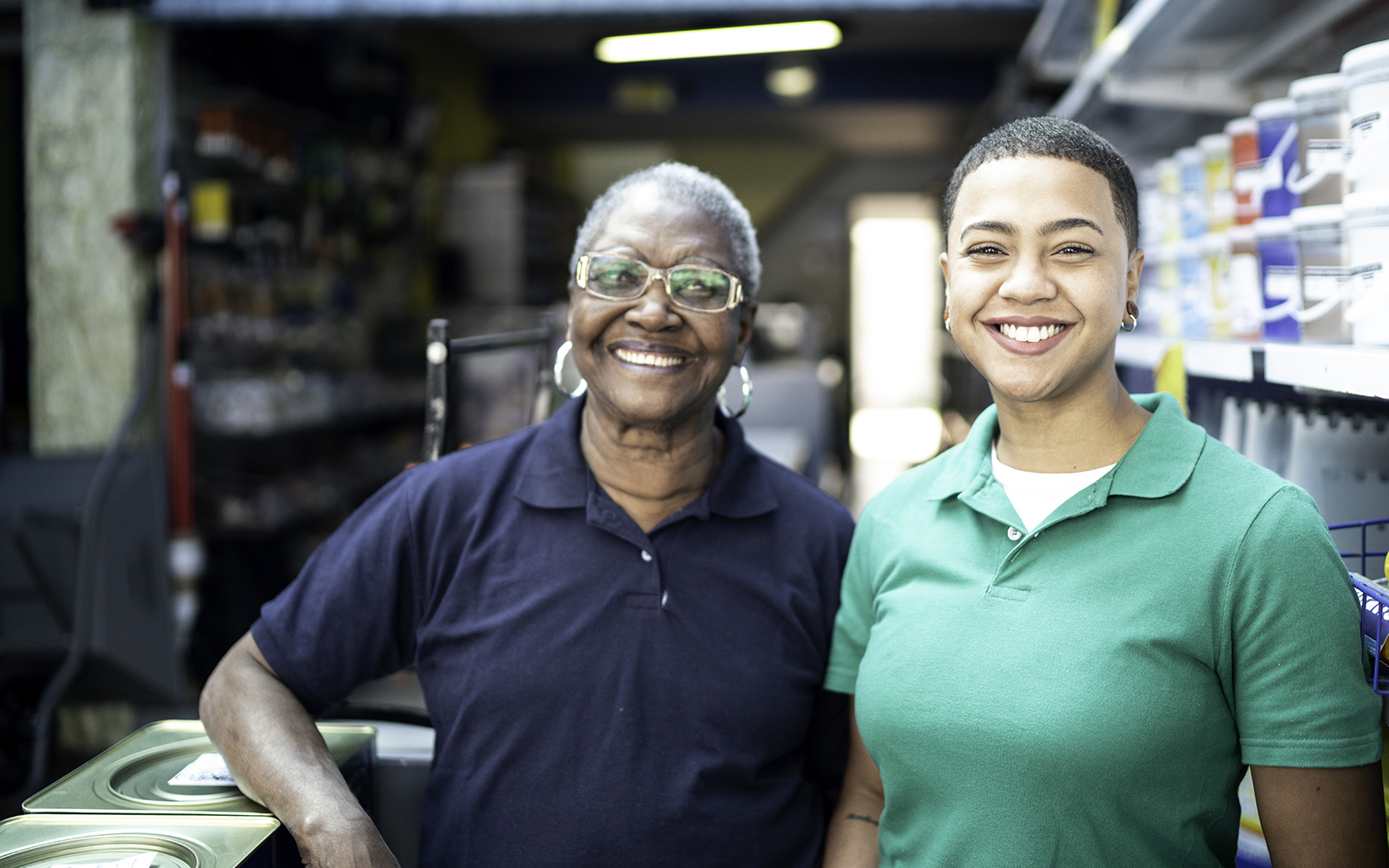 Portrait of mother and daughter working together in a paint store