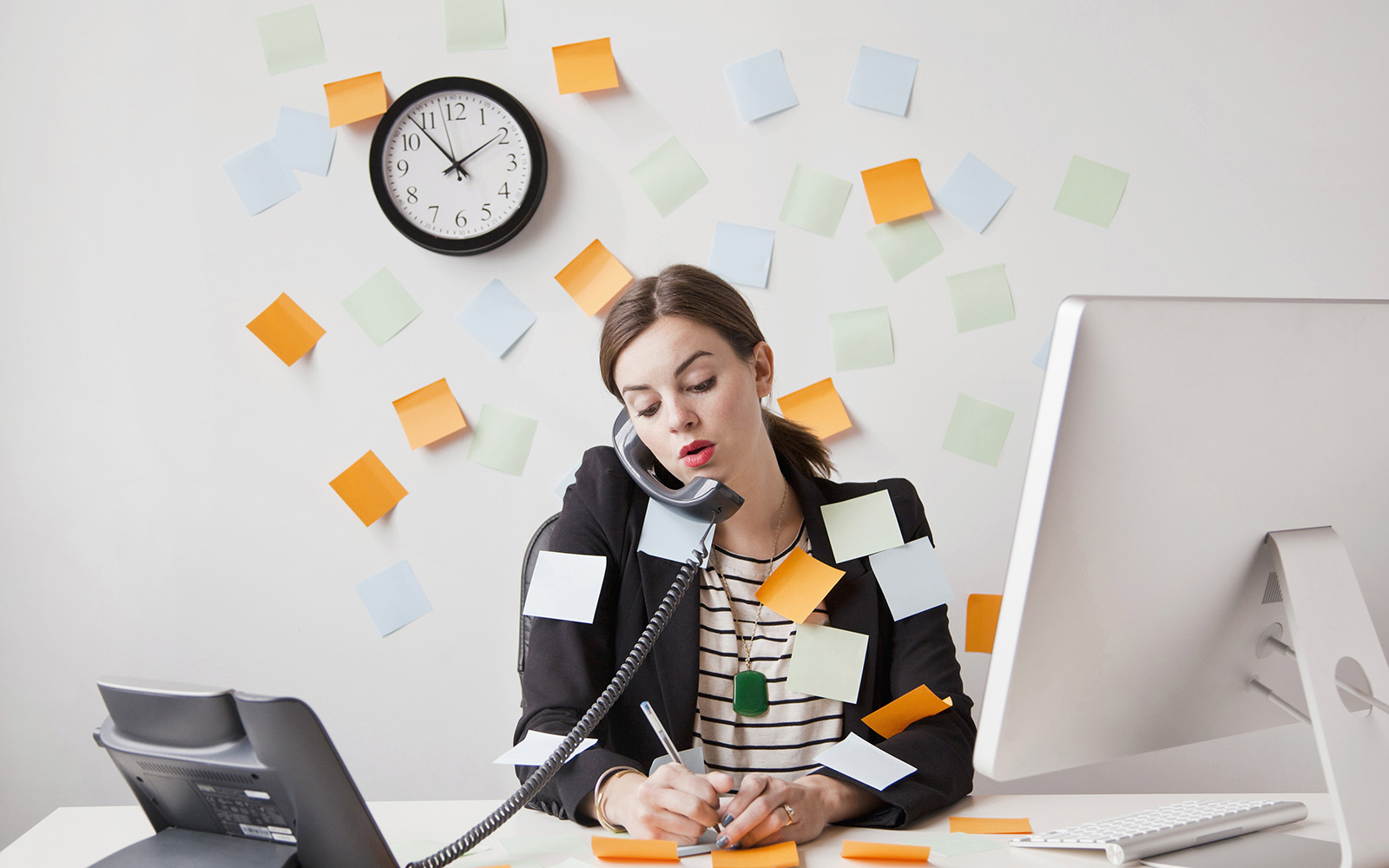 Studio shot of young woman working in office covered with adhesive notes