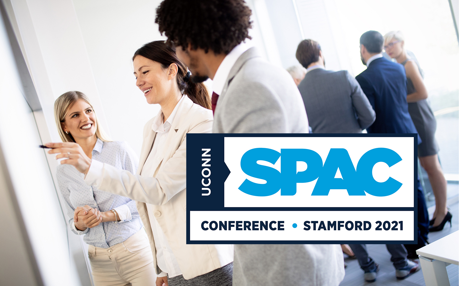 group of people in a conference setting collaborating. UConn SPAC Conference logo bottom right