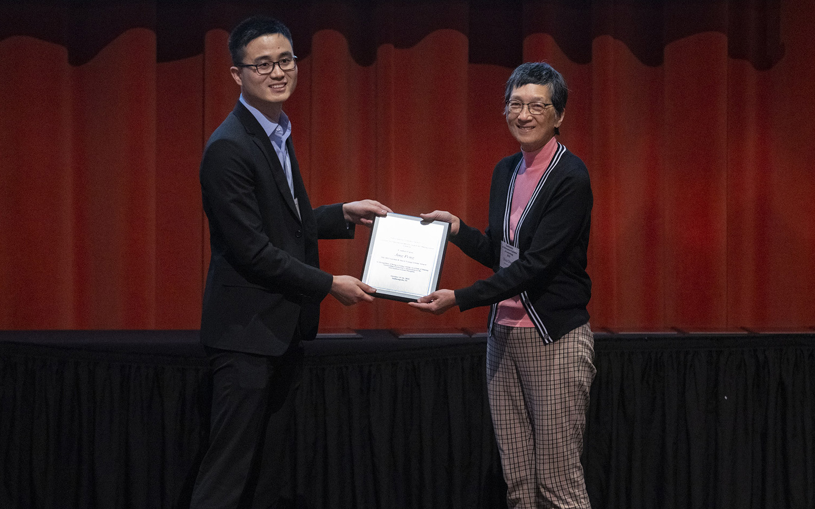 UConn business professor Jing Peng has been honored as one of the most promising young scholars in the information management field. In the photo above, Peng (left) accepts the Gordon B. Davis Young Scholar Award from ISS President Oliver Sheng.