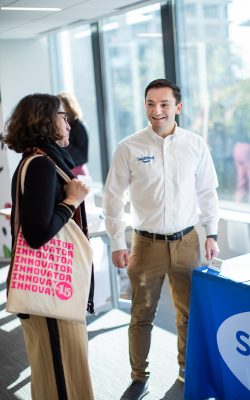 Jeremy Bronen '20 [ENG], right, speaking with attendee Nan Price at the CCEI 15th Anniversary Celebration (Defining Studios)